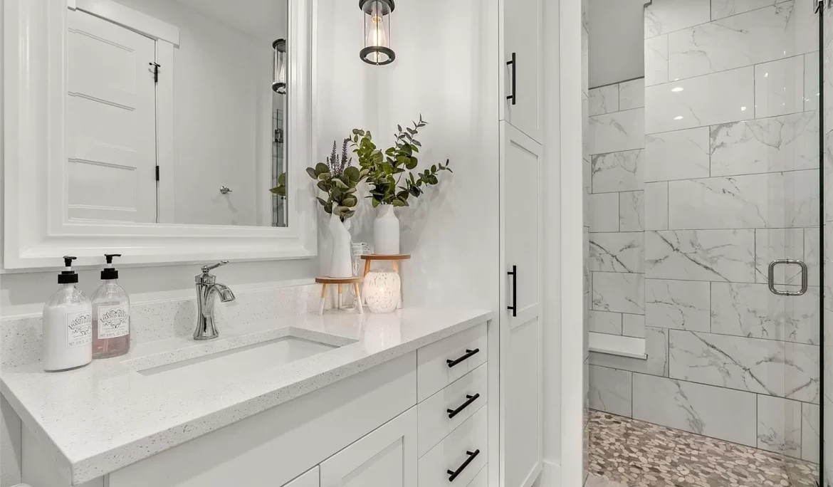 Bright bathroom with white vanity, quartz countertop, black hardware, and walk-in tiled shower