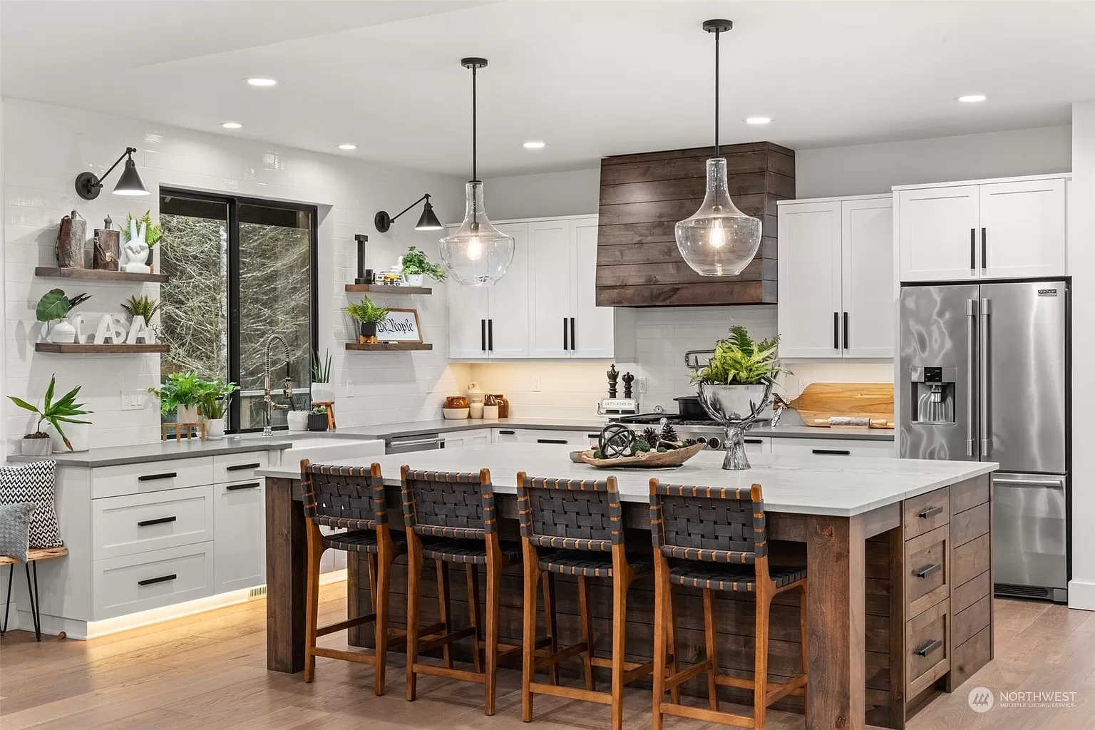 Custom kitchen design in Olympia, WA with white cabinetry, large wood island, and pendant lighting