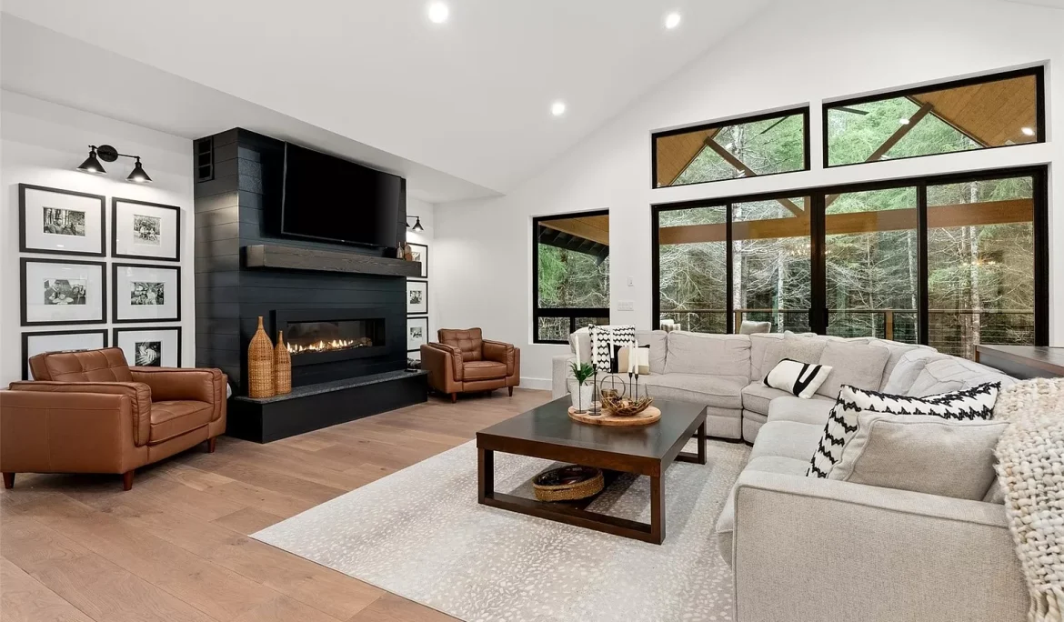 Living room design in Olympia, WA featuring black fireplace wall, leather seating, and large windows