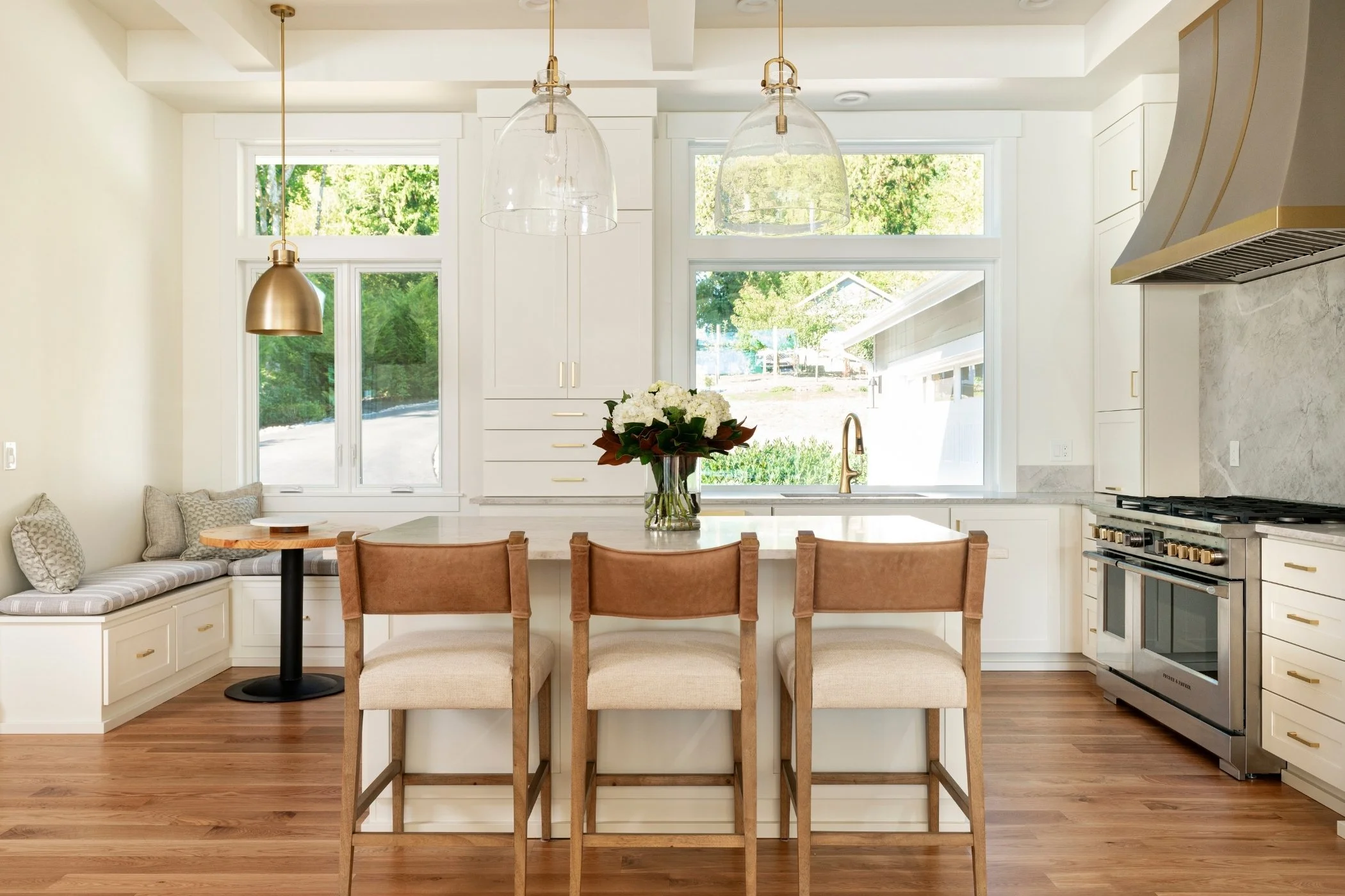 Kitchen island with integrated seating and pendant lighting at Sound View Estate in Olympia, WA